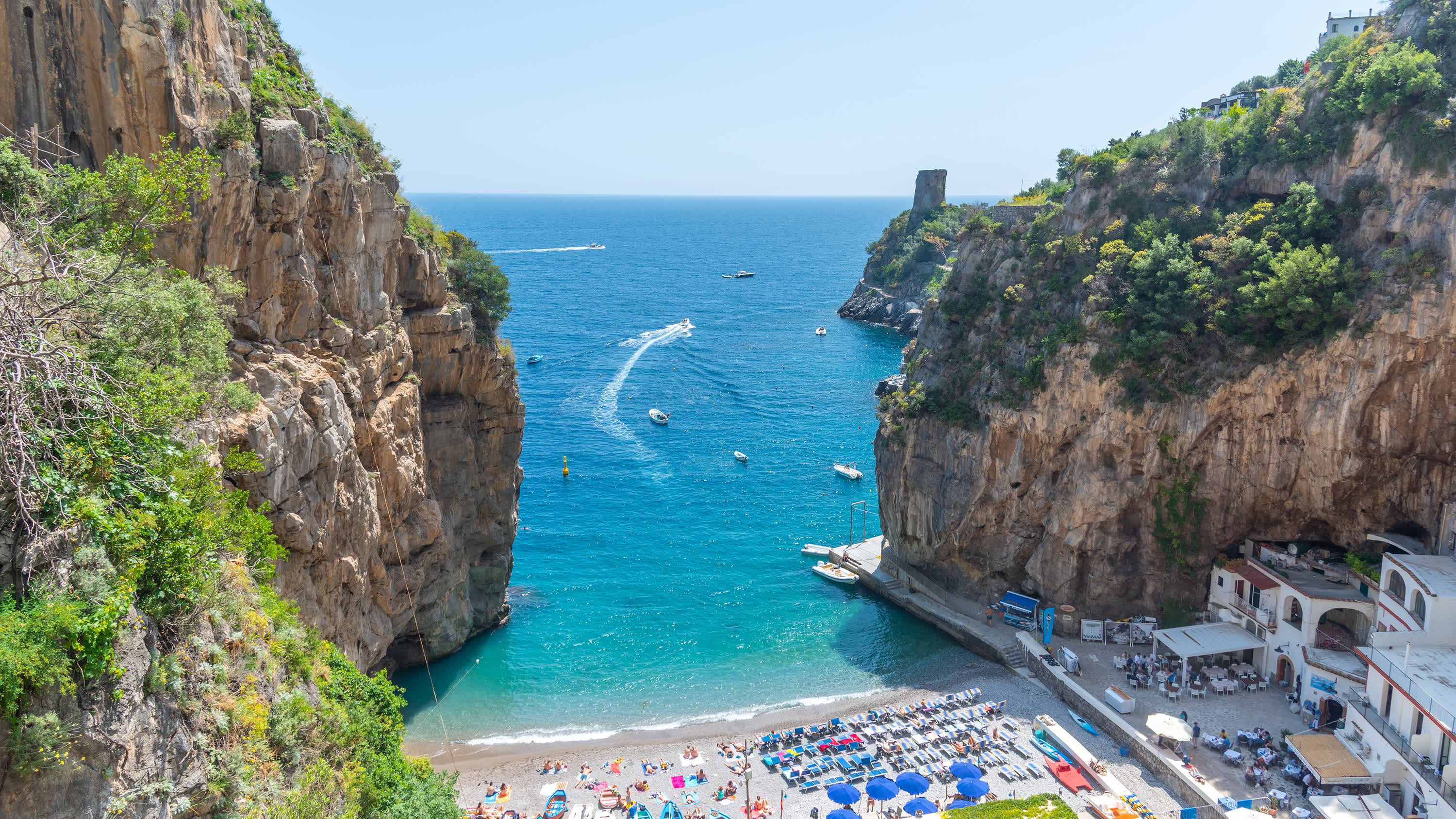 Vue aérienne de la baie de Marina di Praia entre falaises abruptes verdoyantes, sur la côte Amalfitaine, en Italie.