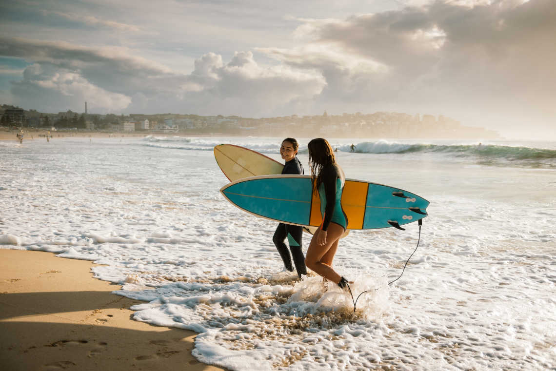 Zwei Surferinnen am Strand von Sydney, Australien.