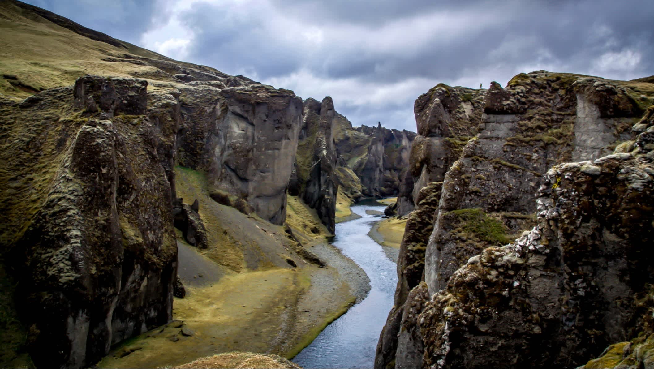 Ein Mann steht auf einer Klippe in der atemberaubenden Fjaðrárgljúfur-Schlucht in Island
