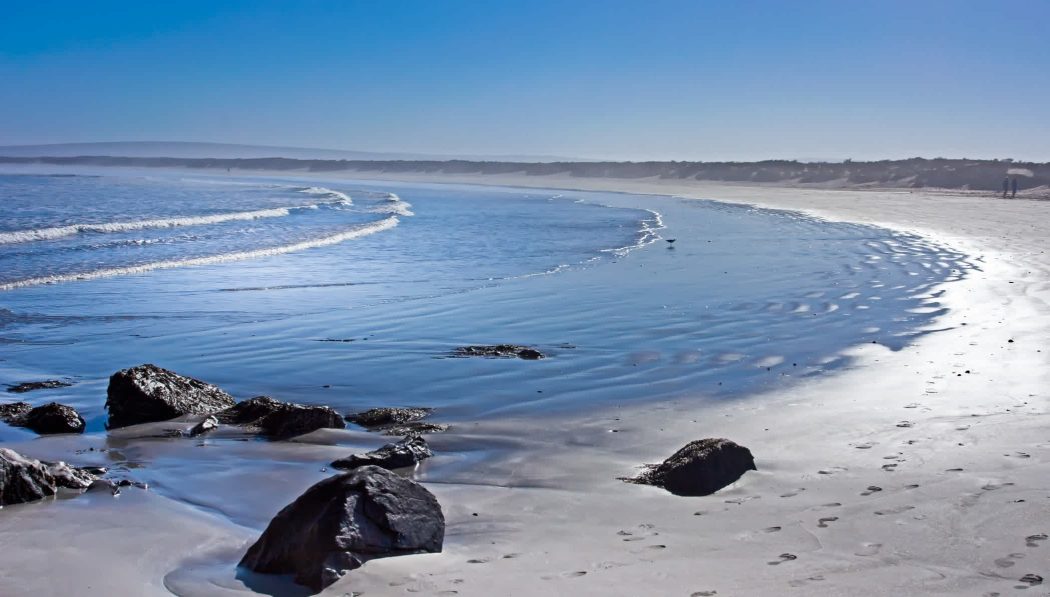 Breiter Strand mit kleinen Wellen am frühen Morgen in Paternoster, Südafrika
