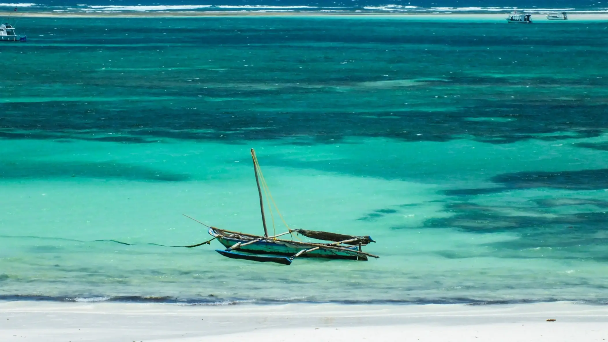 Kenia Shelly Beach Der Luftblick auf das Riff des Strandes Shelly Beach in Kenia in unglaublich türkisenem Wasser und mit einem traditionellen Boot im Bild.