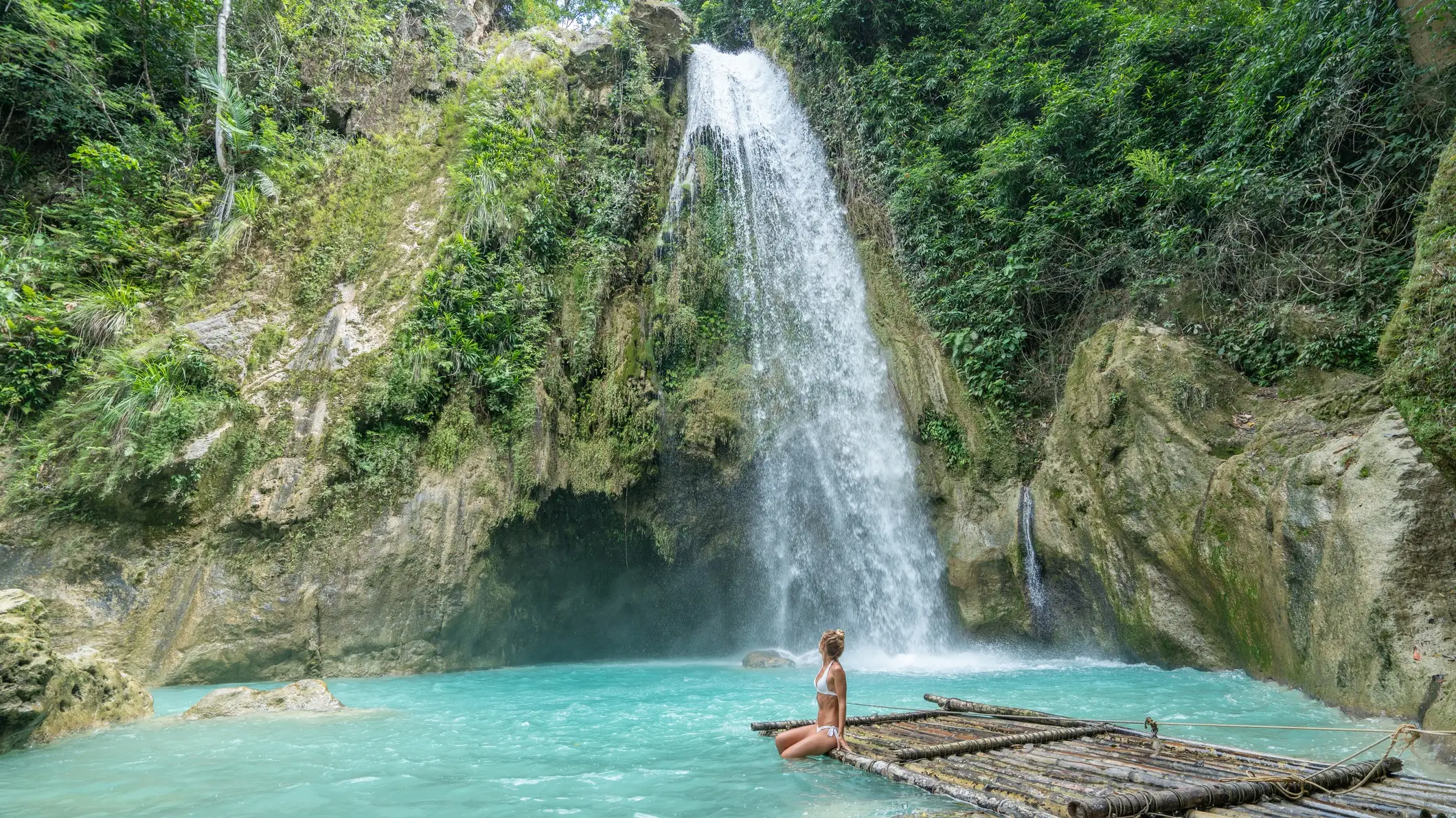 Cebu, Visayas, Philippinen Wasserfall mit türkisfarbenem Pool und Bambusfloß in tropischer Natur, Cebu, Visayas, Philippinen.