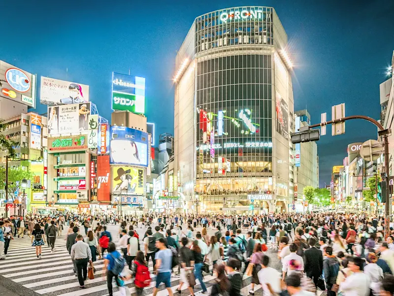 Japan, Kantō, Tokio Eine belebte Kreuzung mit hell erleuchteten Gebäuden, bekannt als Shibuya Crossing. Tokio, Kantō, Japan.
