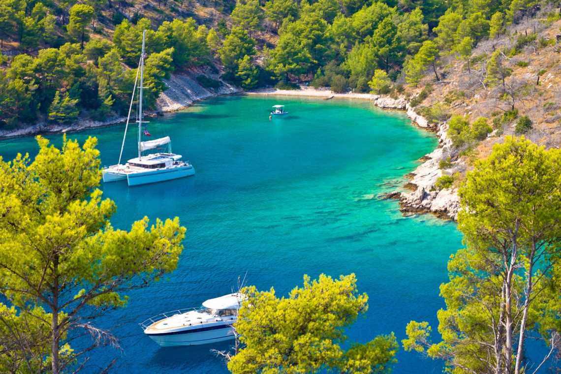 Yachten auf dem Wasser einer türkisfarbenen Bucht auf der Insel Brac, Dalmatien, Kroatien.