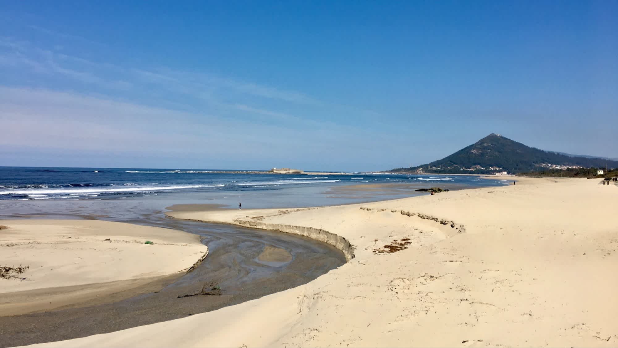 Der Strand von Praia de Moledo, Caminha, Portugal bei Ebbe und mit Weitblick auf den Sand und Berge im Hintergrund. 