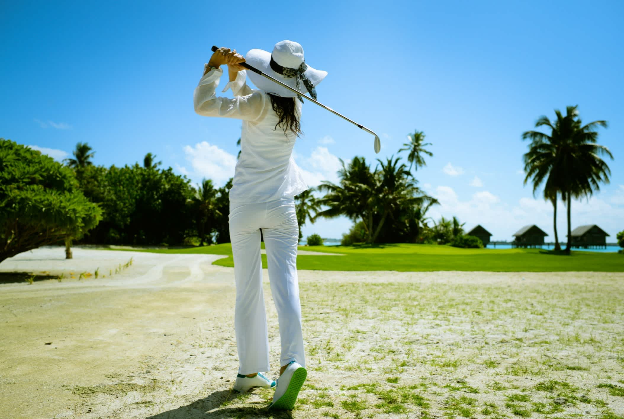 Une jeune femme joue au golf sur un terrain en bord de mer, Espagne