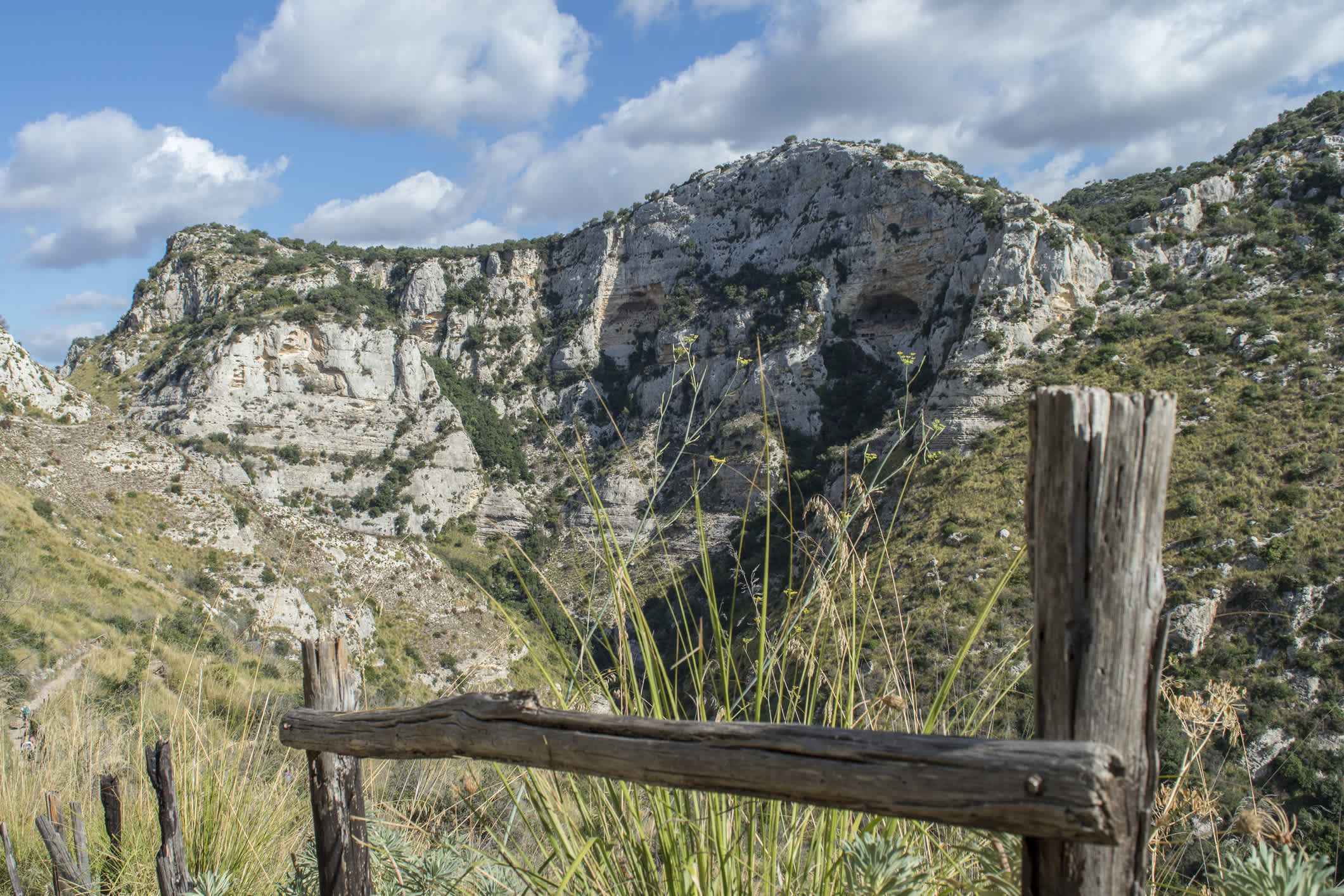 Rembarde en bois avec un paysage montagneux en arrière-plan, au Cavagrande del Cassibile, en Sicile, en Italie.