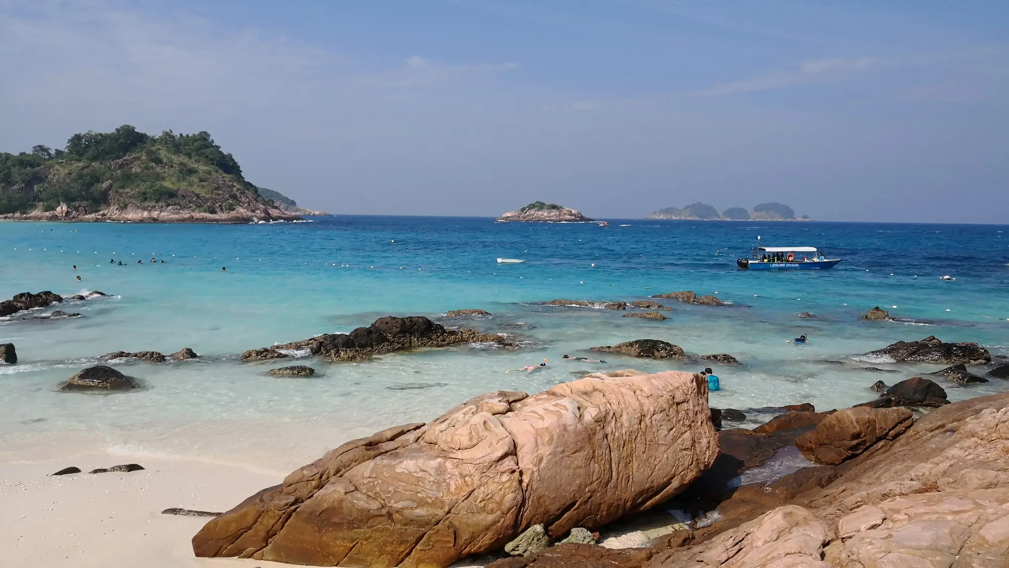 Felsen und türkisblaues Wasser am Strand auf den Pulau Redang, Malaysia, 