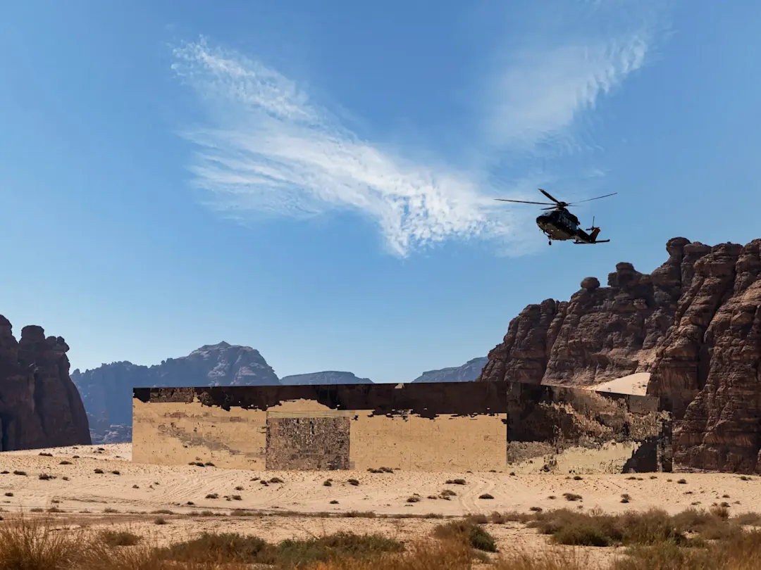 Ein Hubschrauber über dem spiegelnden Maraya-Konzertsaal. Al Ula, Provinz Medina, Saudi-Arabien.