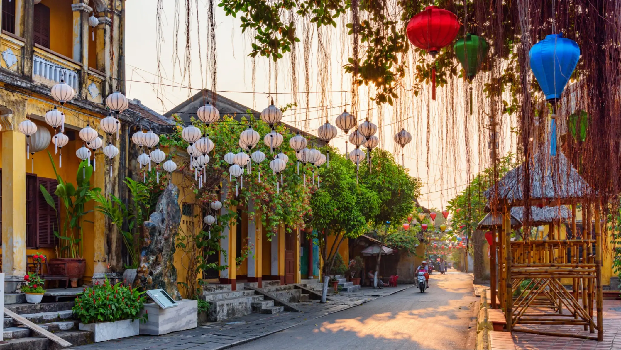 Magnifique vue sur cette rue animée, décorée de lanternes en soie colorées au lever du soleil. Les pittoresques maisons traditionnelles jaunes de la vieille ville de Hoi An, au Vietnam.
