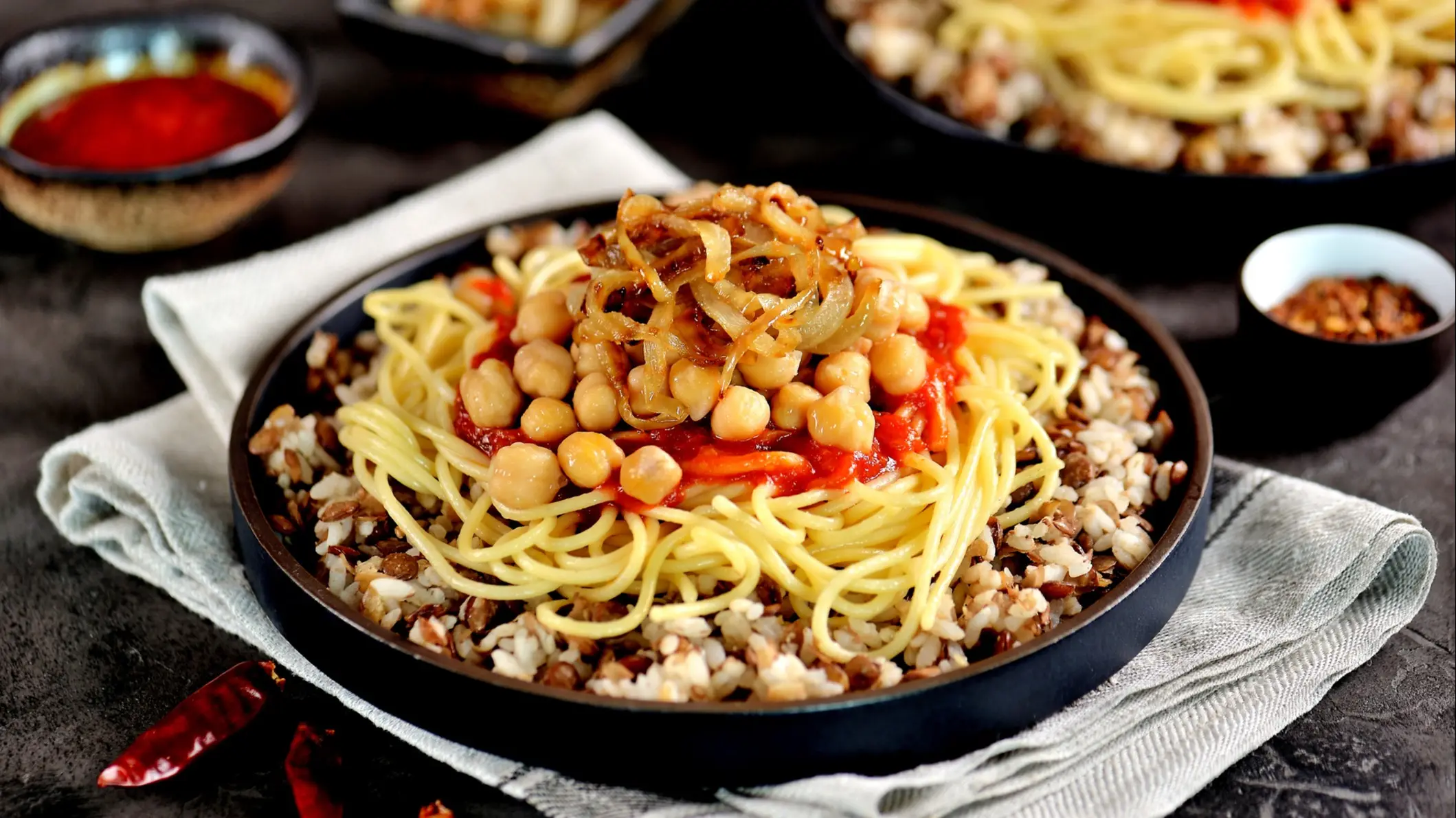 Ägypten, Koshari Kushari oder Koushari - ägyptischen Gericht aus Reis, Nudeln, Linsen, Kichererbsen mit Tomaten-Sauce und knusprigen Zwiebeln.