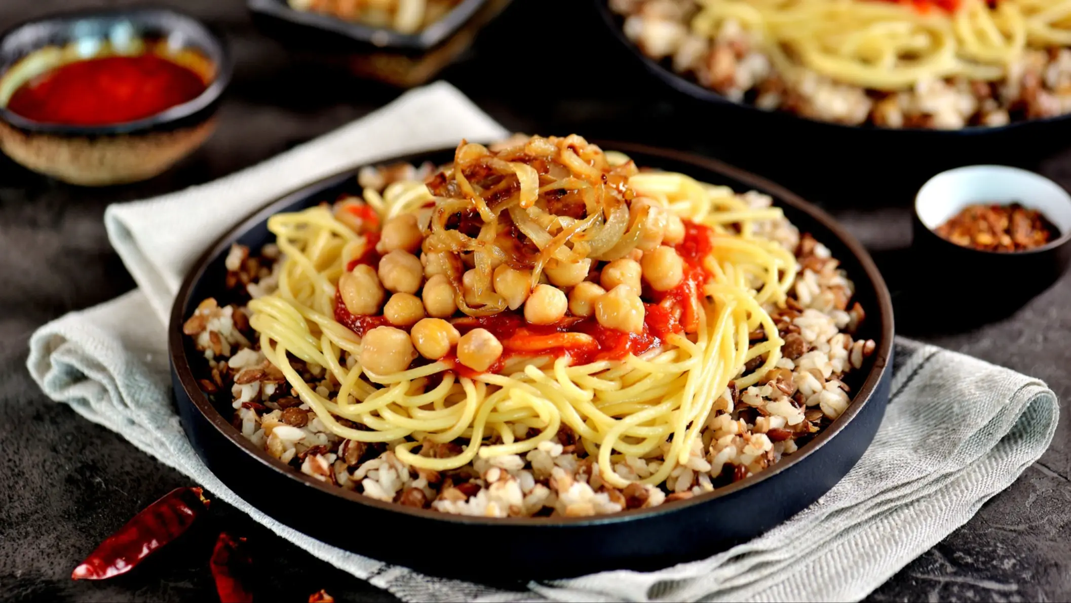 Kochari ou Koushari - plat égyptien à base de riz, de pâtes, de lentilles, de pois chiches avec une sauce tomate et des oignons croustillants.

