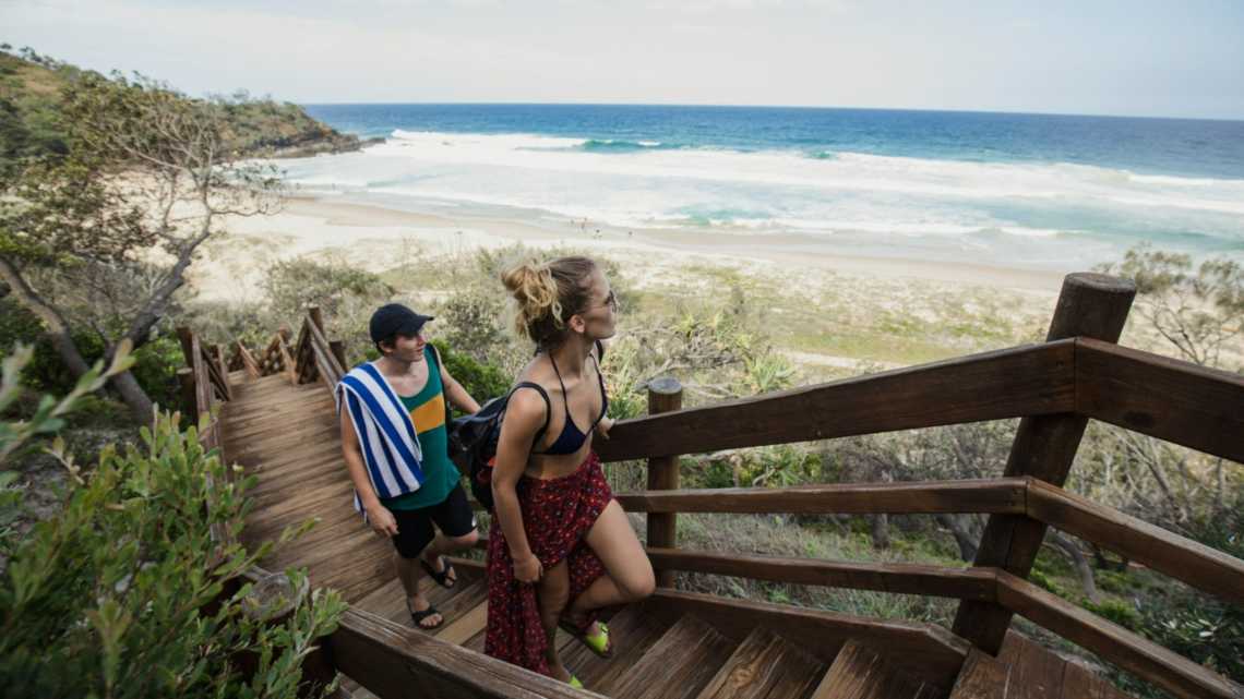 Jeune couple explorant Sunrise Beach à Noosa Heads, Queensland, Australie.
