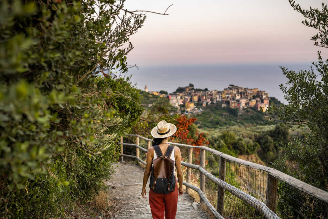 Une voyageuse en randonnée sur les hauteurs du village côtier de Corniglia, dans la région des Cinque Terre en Italie.
