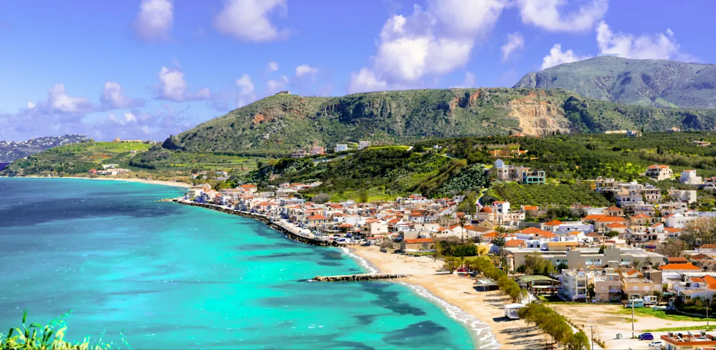 Griechenland, Kreta, Rethymno Küstendorf mit türkisfarbenem Meer und Hügeln. Rethymno, Kreta, Griechenland.