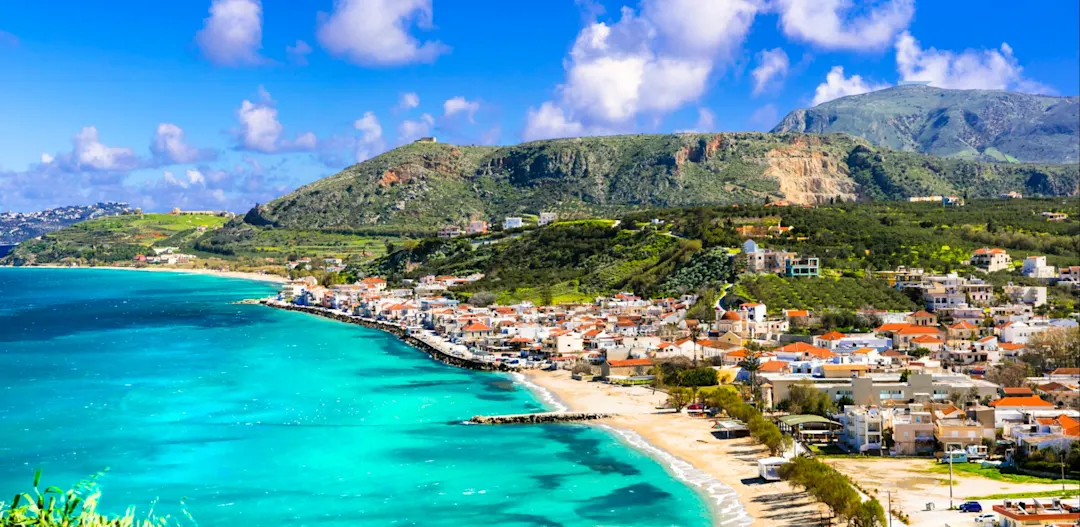 Küstendorf mit türkisfarbenem Meer und Hügeln. Rethymno, Kreta, Griechenland.