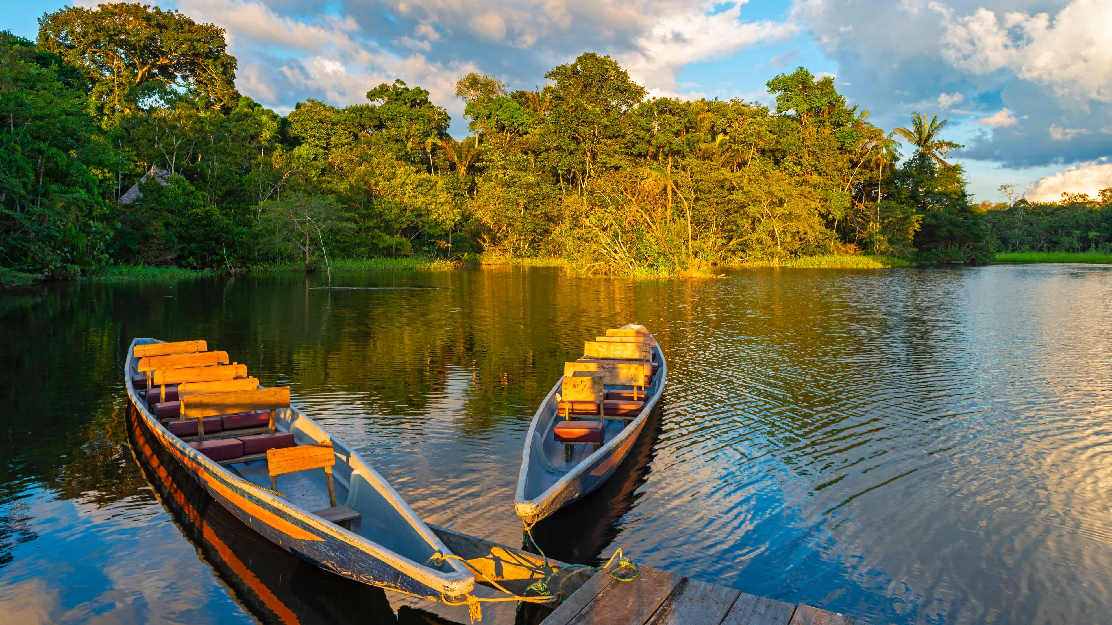 Canoës au coucher du soleil dans la forêt amazonienne