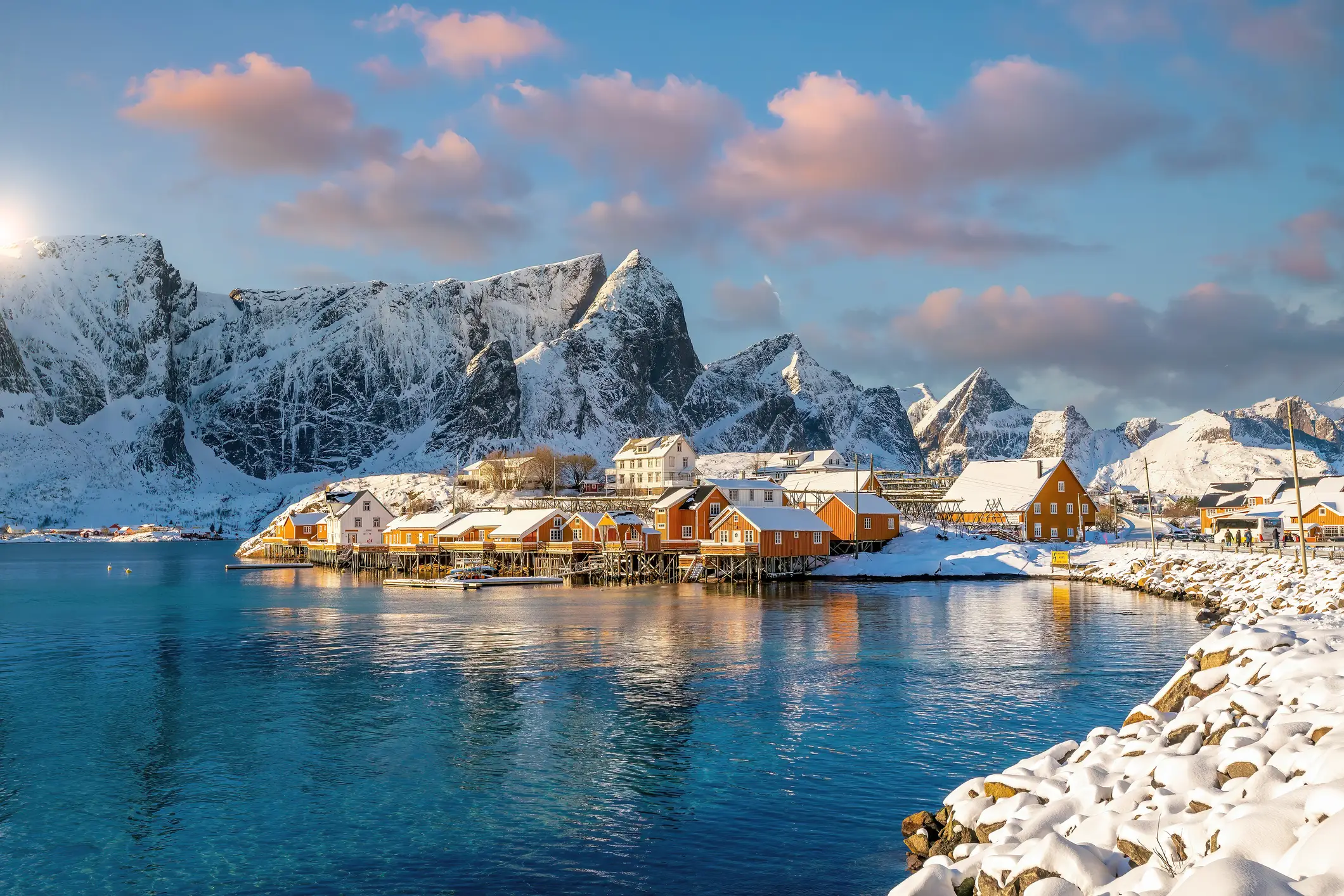 Cabanes de pêcheurs rouges traditionnelles au bord de l'eau, au milieu d'un paysage enneigé sur les îles Lofoten en Norvège.