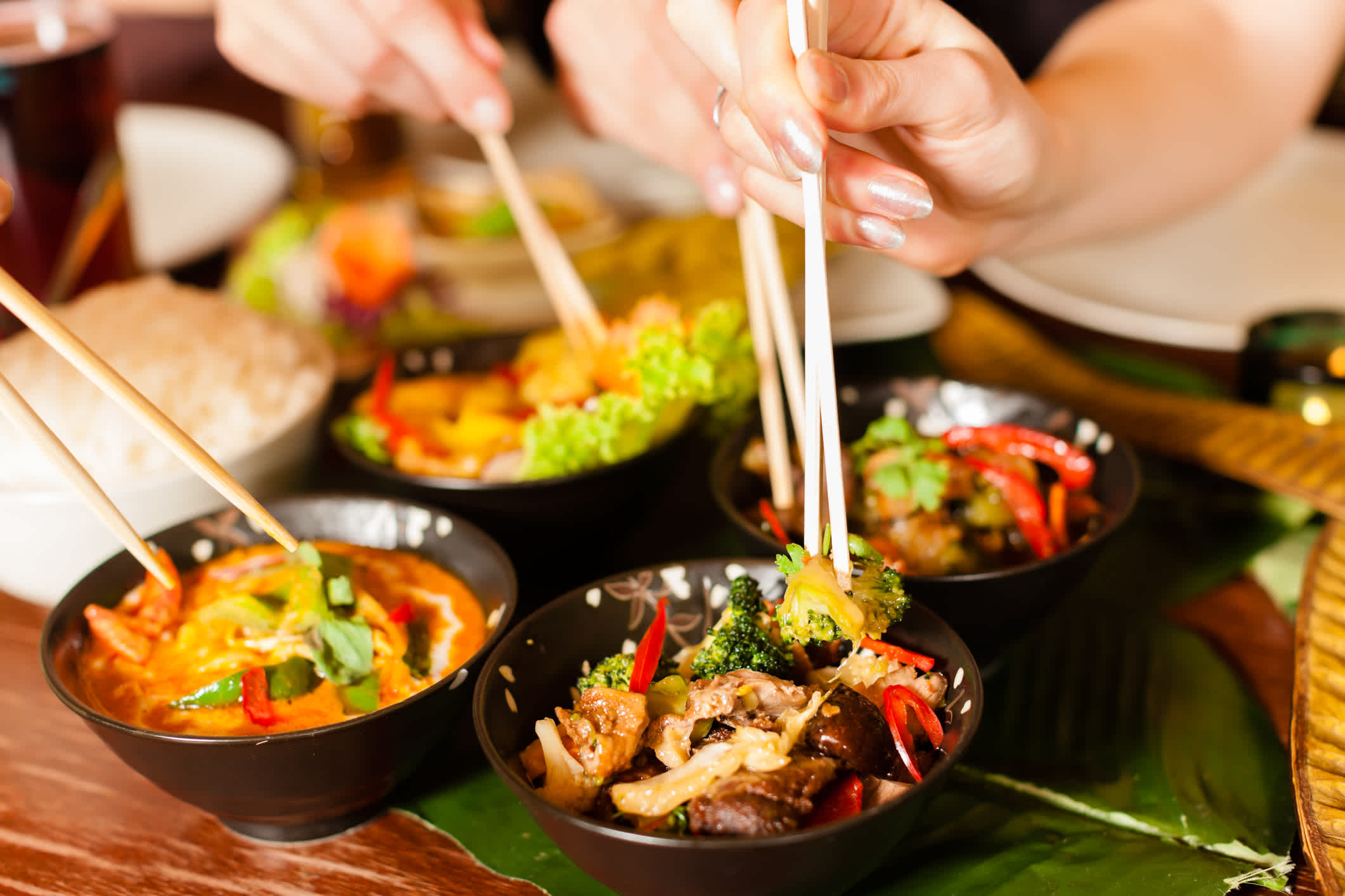 Leute essen mit Essstäbchen in einem thailändischen Restaurant