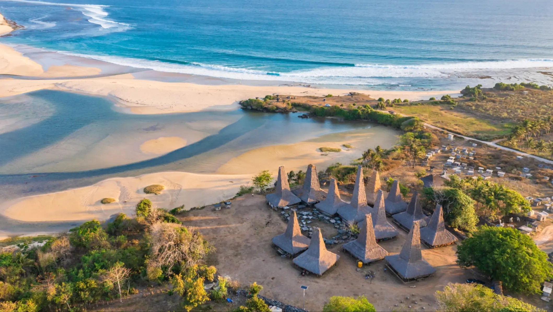 Vue aérienne prise par drone du village de Ratenggaro, avec ses maisons traditionnelles et son magnifique littoral, au coucher du soleil, sur la côte ouest de l'île de Sumba, en Indonésie