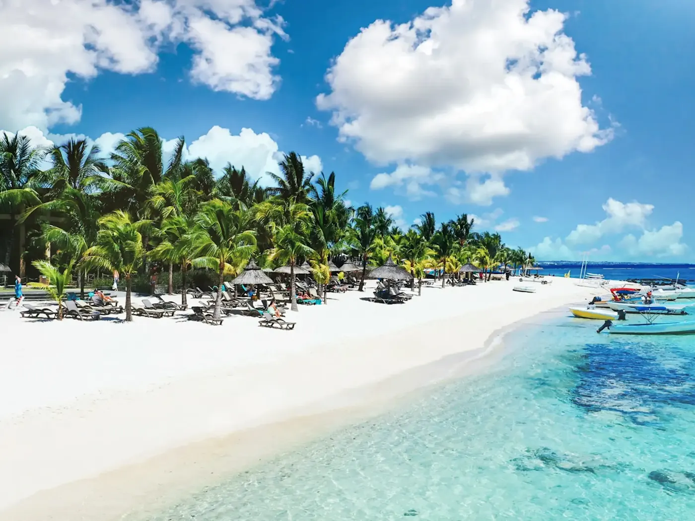 Weißer Sandstrand mit Palmen und Booten, Grand Baie, Rivière du Rempart, Mauritius.