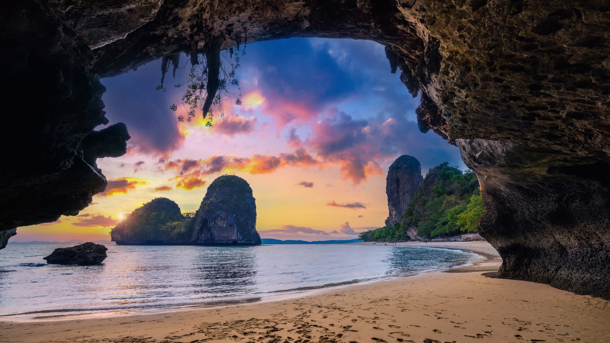 Une grotte avec vue sur la plage de Phra Nang, en Thaïlande au coucher du soleil