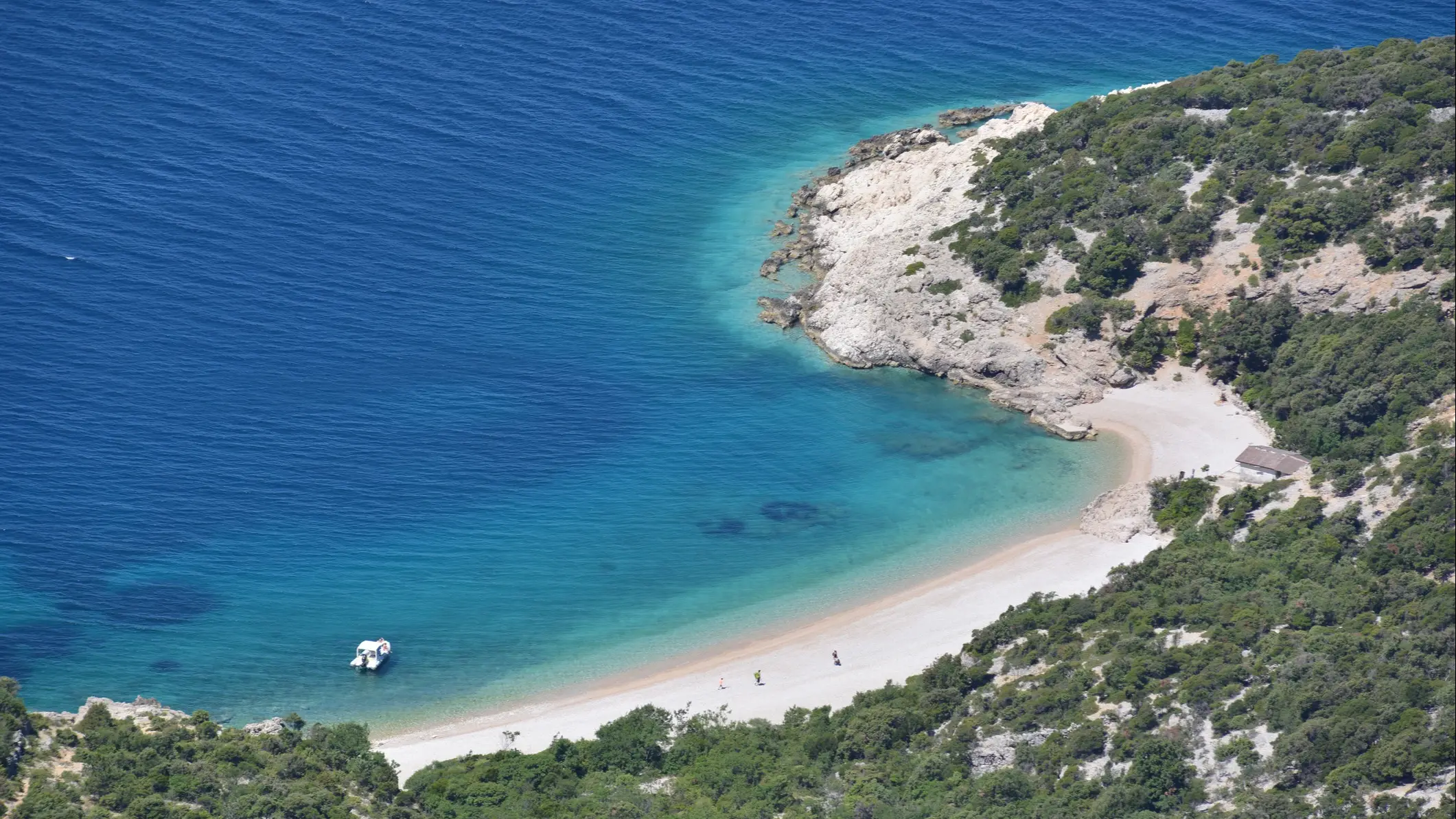 Kroatien Sveti Ivan Der Strand von Sveti Ivan, Insel Cres, Kroatien mit Blick auf den gefüllten Strand und den Berghängen mit Häusern.