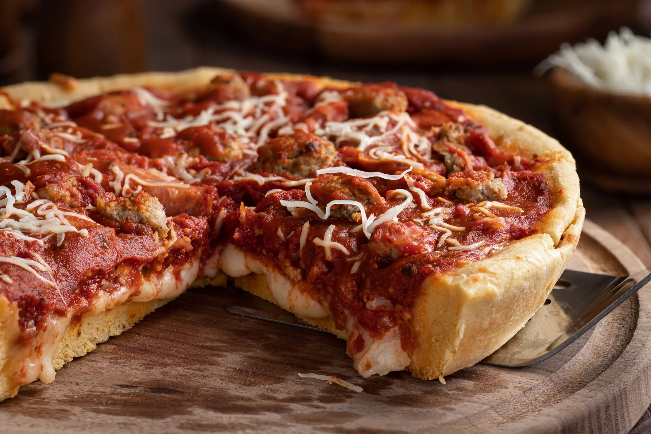 Nationalgerichte, USA, Chicago-style Pizza Nahaufnahme einer Pizza nach Chicagoer Art auf einer Holzplatte.
