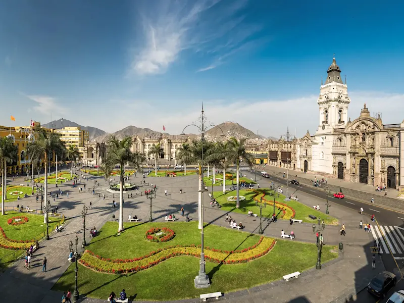 Peru, Lima, Plaza de Armas Lebhafte Plaza Mayor mit Kolonialarchitektur und Bergen im Hintergrund, Lima, Peru.