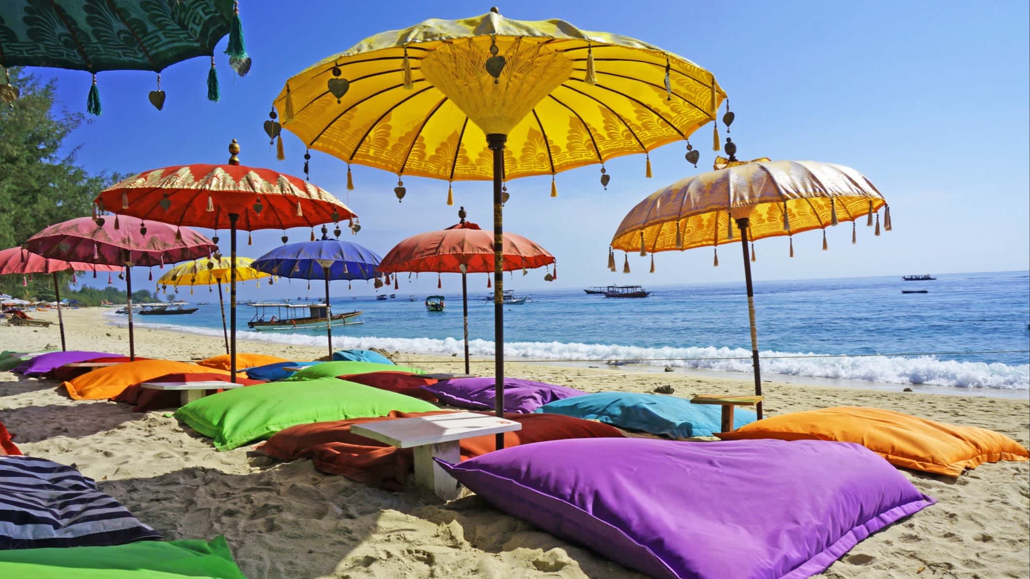 Photo de parasols et de coussins colorés sur une plage de Bali, en Indonésie.