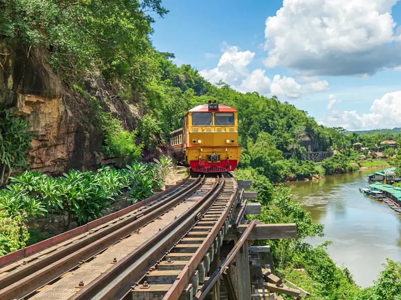 Thaïlande, Kanchanaburi, Chemin de fer de la mort Un train jaune traverse la jungle dense le long du Death Railway, Kanchanaburi, Thaïlande.