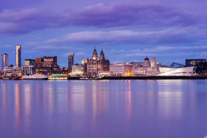 Discover the majestic waterfront city of Liverpool on a Liverpool vacation, pictured here at night