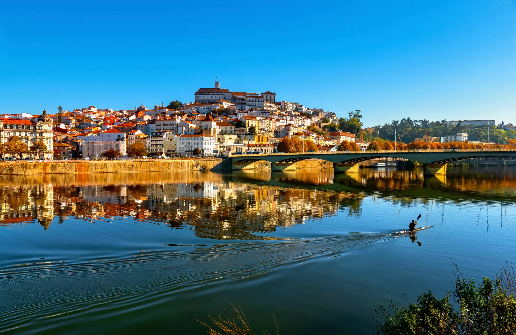 Vue de Coimbra et du fleuve Mondego avec des kayakistes, Portugal.