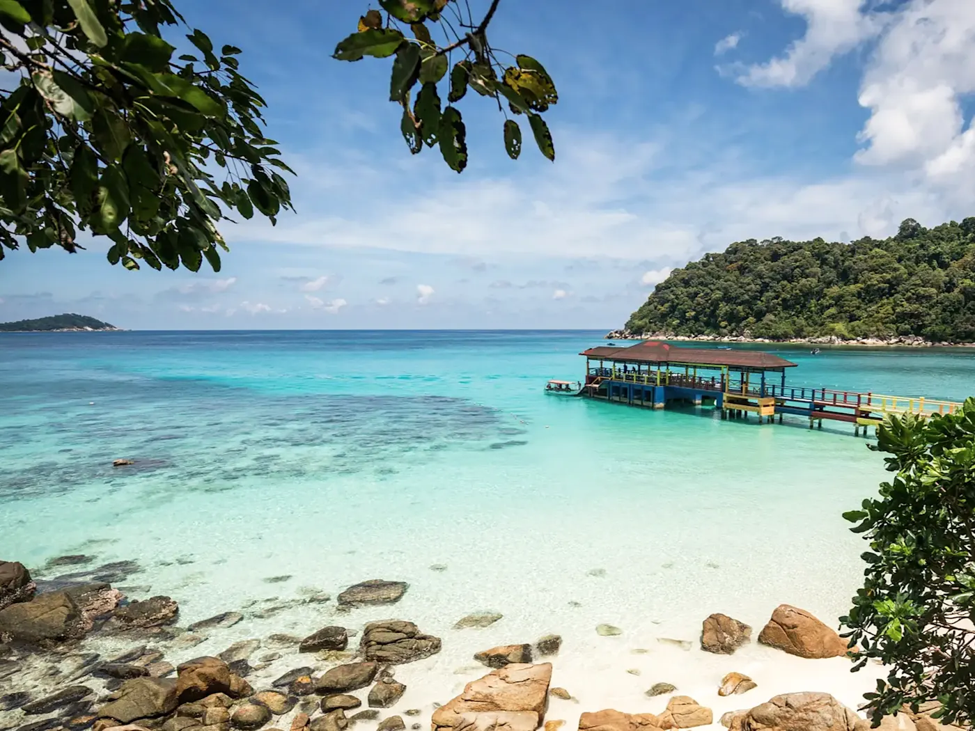 Holzsteg über türkisfarbenem Wasser und Sandstrand. Perhentian-Inseln, Terengganu, Malaysia.