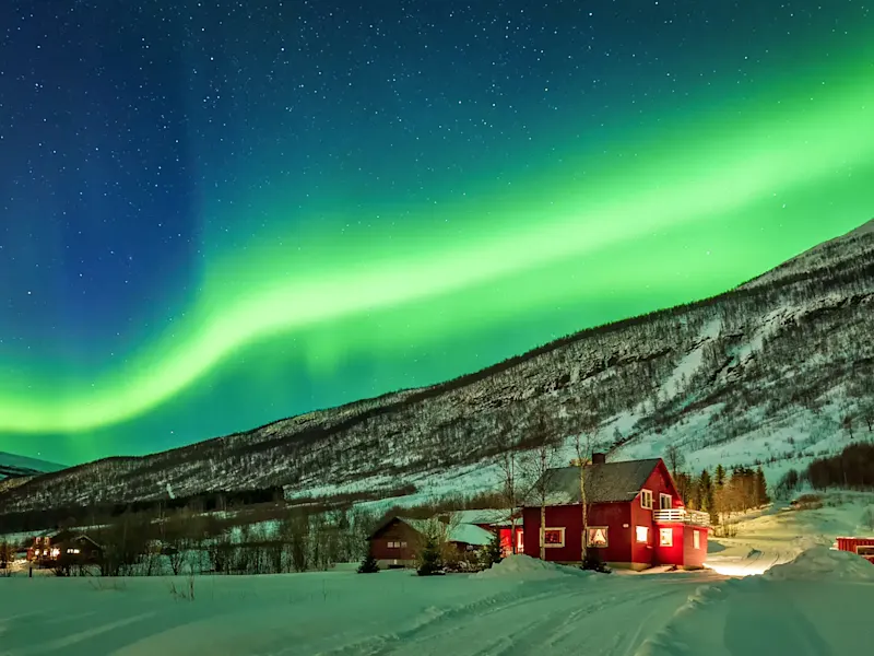 Norvège, Lofoten, Svolvær, aurores boréales Aurores boréales au-dessus d'un chalet rouge dans un paysage enneigé. Svolvær, Lofoten, Norvège.