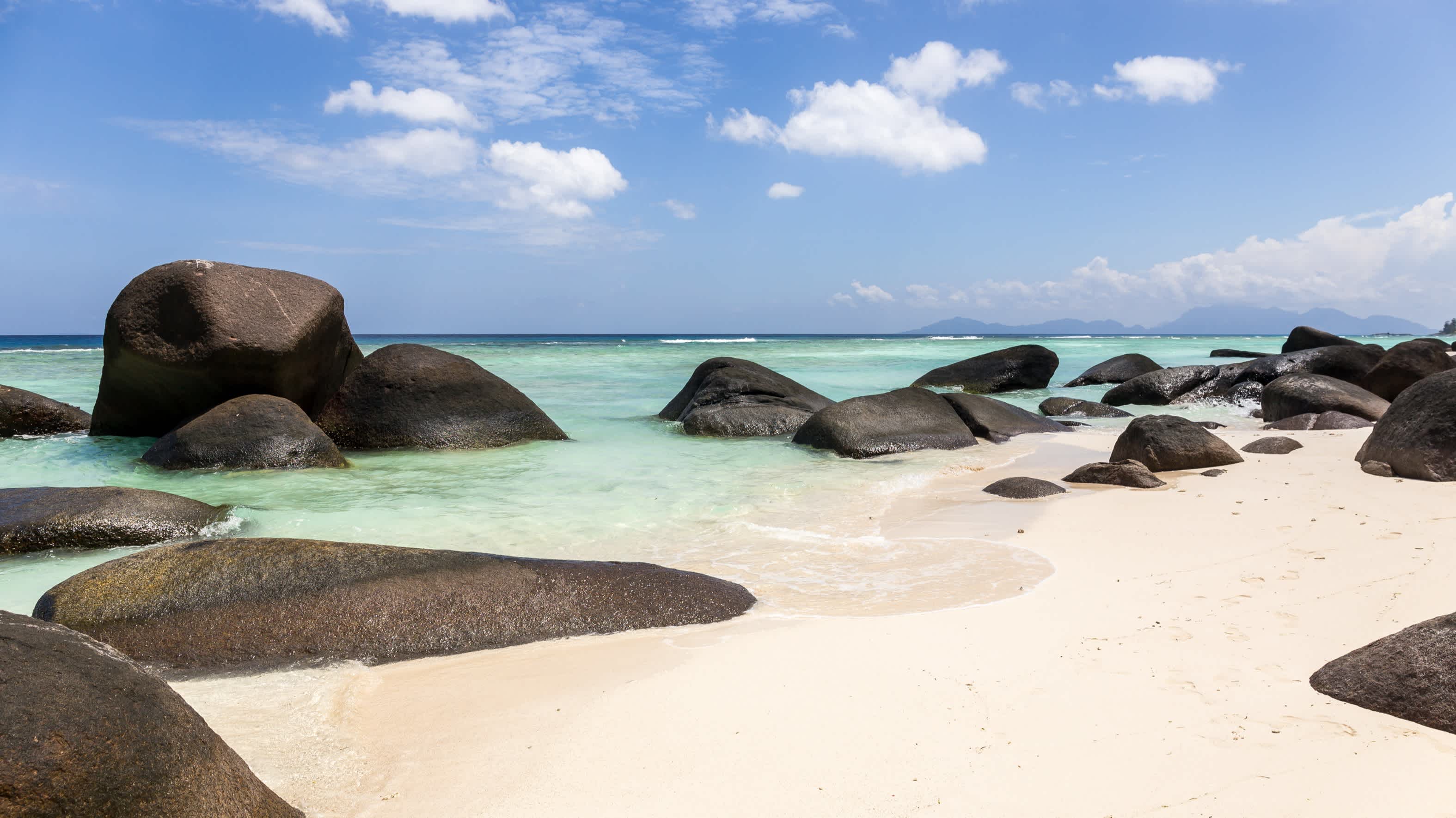 Schöner Strand Anse La Passe und türkisfarbenes Meer auf der Insel Silhouette, Seychellen bei Sonne pur und mit tollen Granitfelsen im Bild. 

