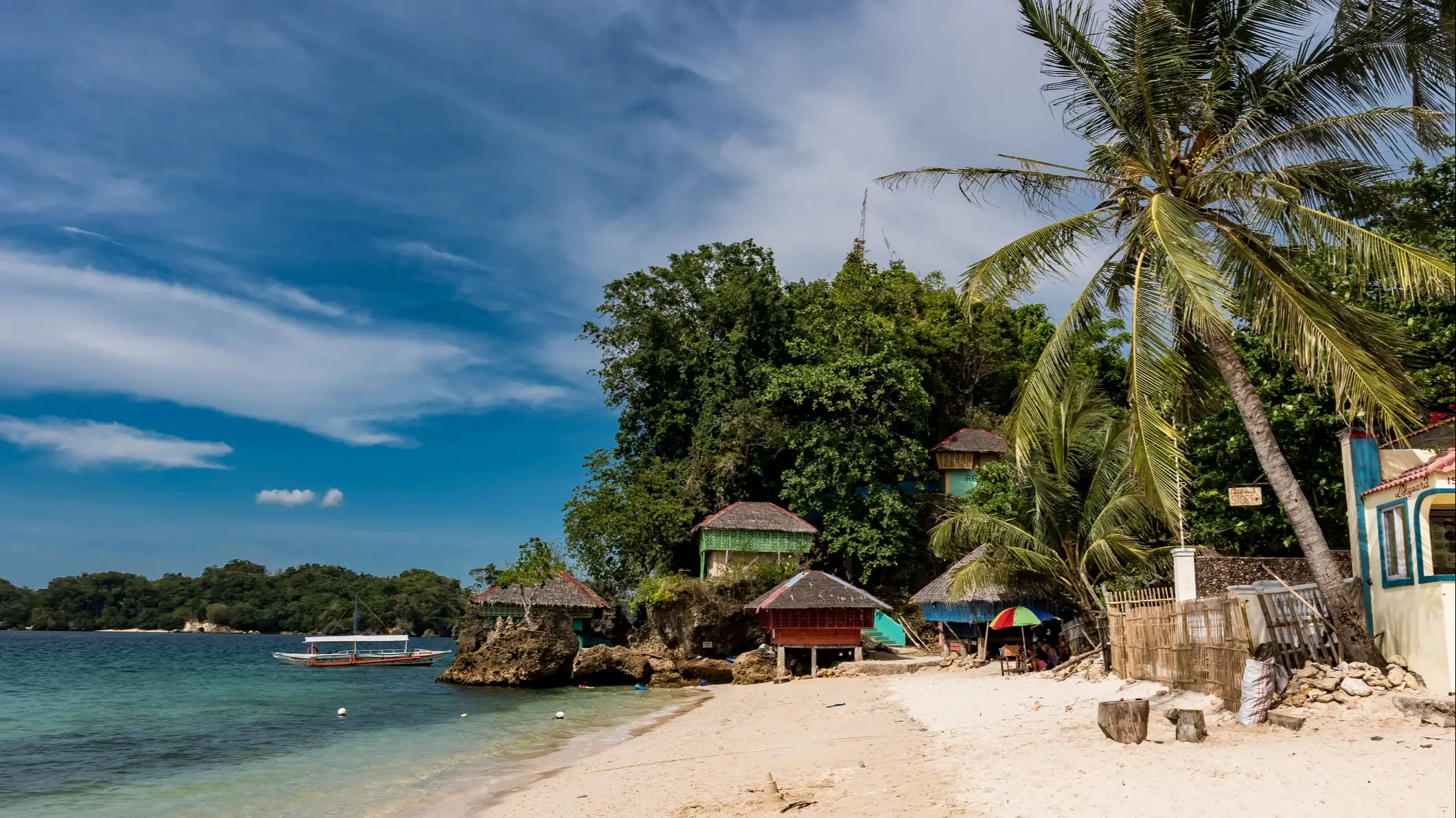 Guimaras, Philippinen Strand mit Palmen, Bambushütten und Boot am Meer, Nueva Valencia, Guimaras, Philippinen.