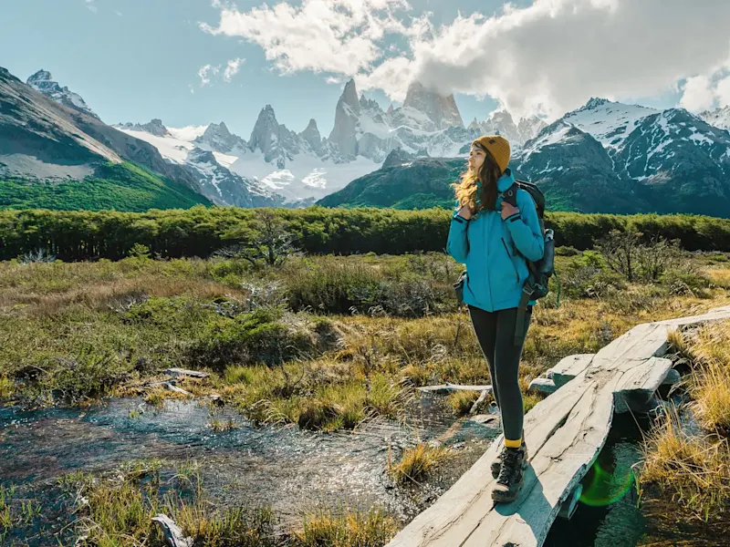 Argentine, Santa Cruz, El Chaltén Randonneuse sur un pont en bois avec des montagnes en arrière-plan, El Chaltén, Santa Cruz, Argentine.