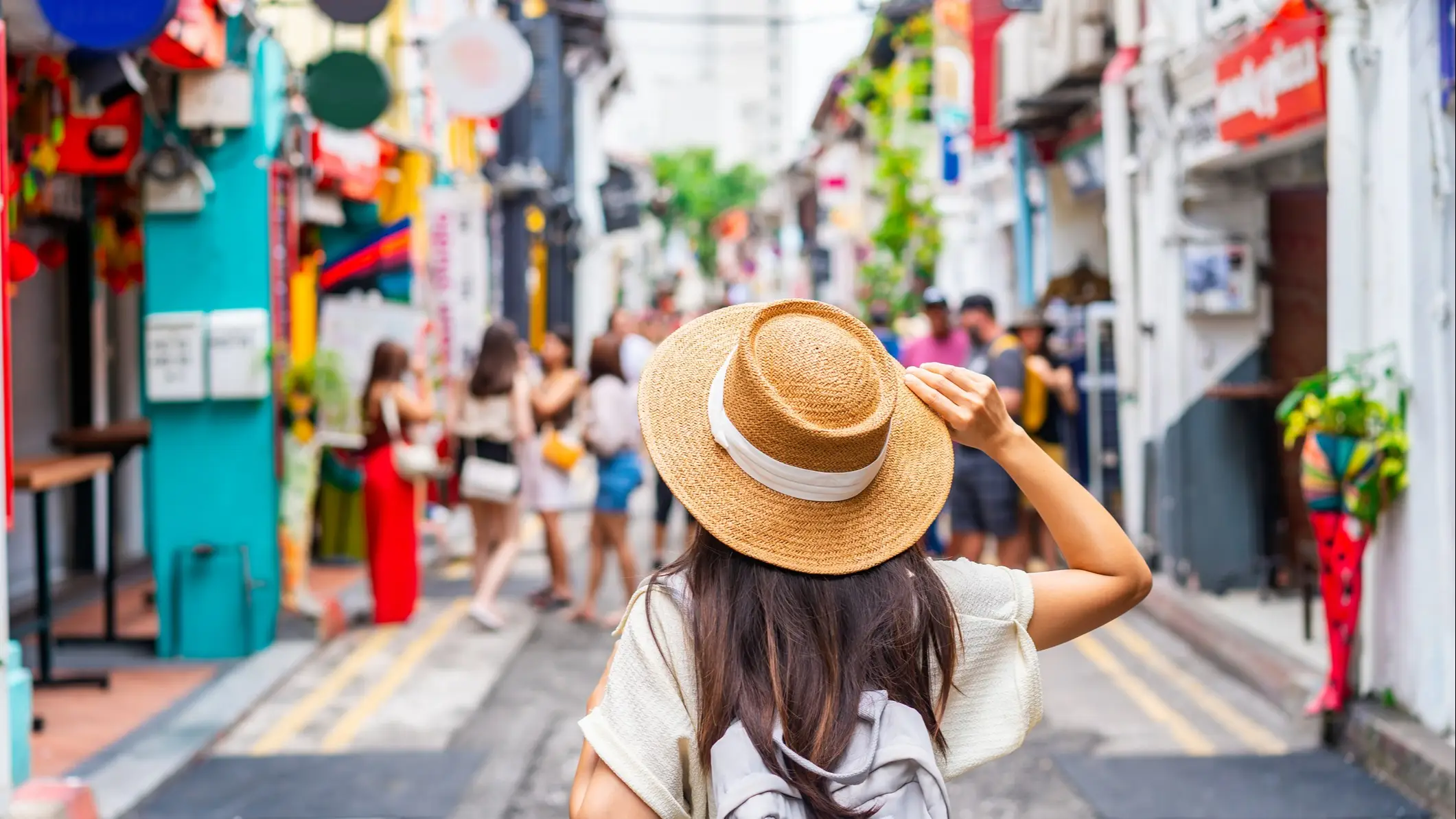 Jeune touriste avec un sac à dos et un chapeau se promenant dans Haji Lane à Singapour.