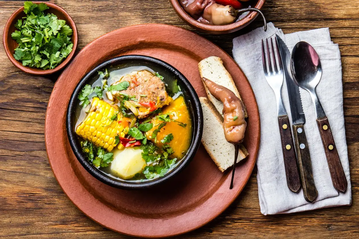 Chile, Cazuela Lateinamerikanisches chilenisches Essen. Traditionelle chilenische Cazuela de Cerdo mit Chuchoca. Schweinefleischsuppe mit Kartoffeln, Kürbis. Mais serviert in Tonschale aus Pomaire. Draufsicht