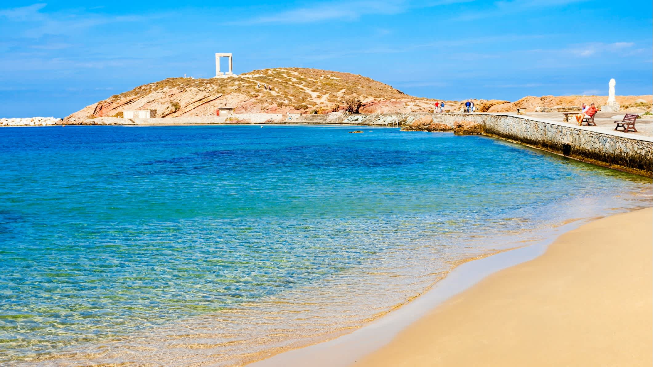 Plage de sable avec une mer turquoise et la Portara de Naxos en arrière-plan, en Grèce
