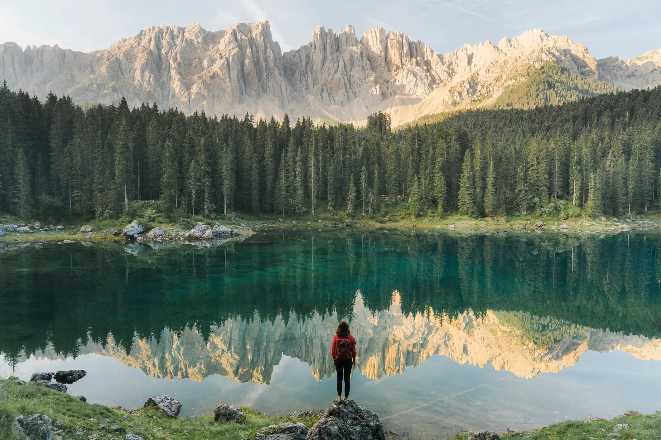 Frau stehend und mit Blick auf den Lago di Carezza in Dolomiten