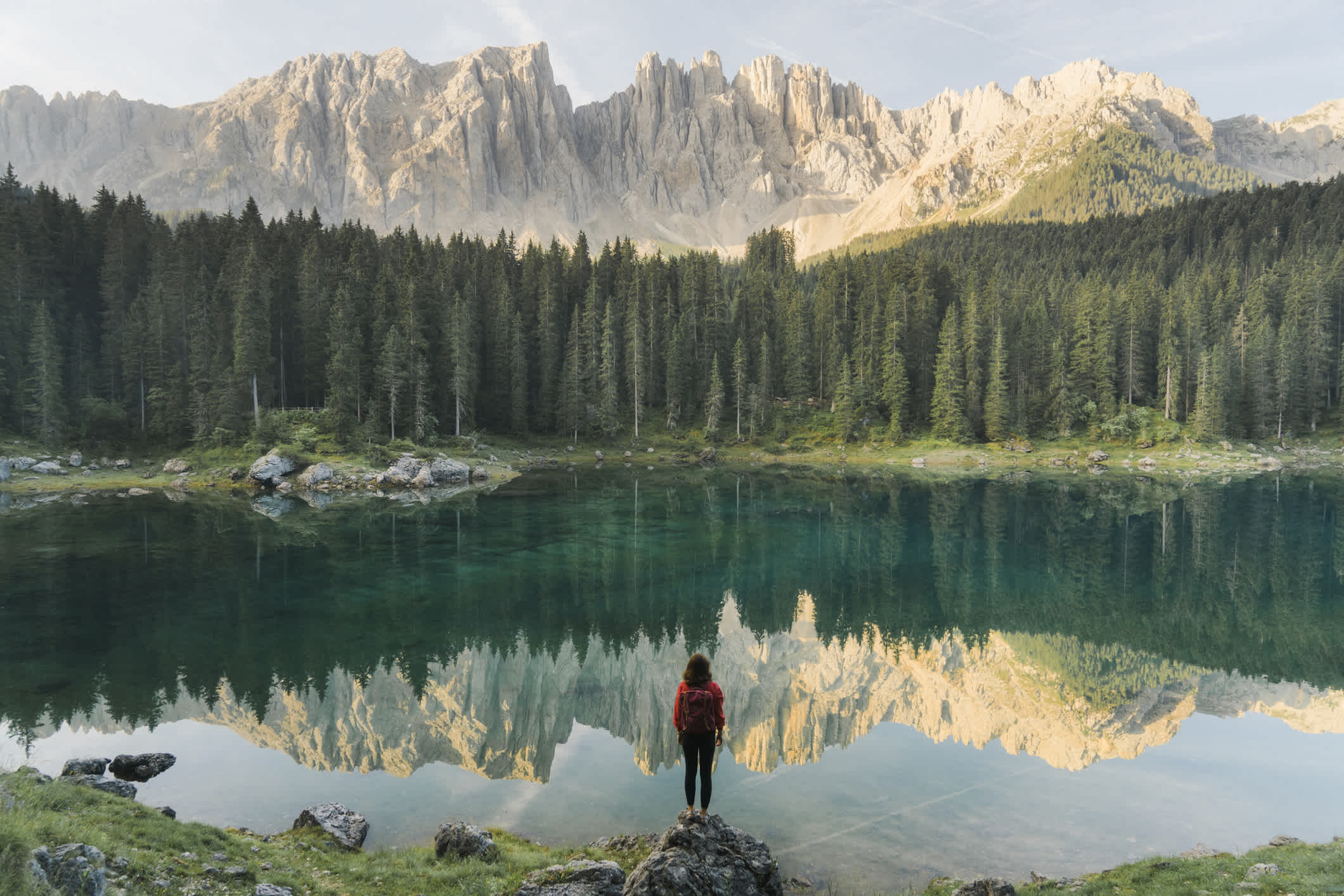 Frau stehend und mit Blick auf den Lago di Carezza in Dolomiten