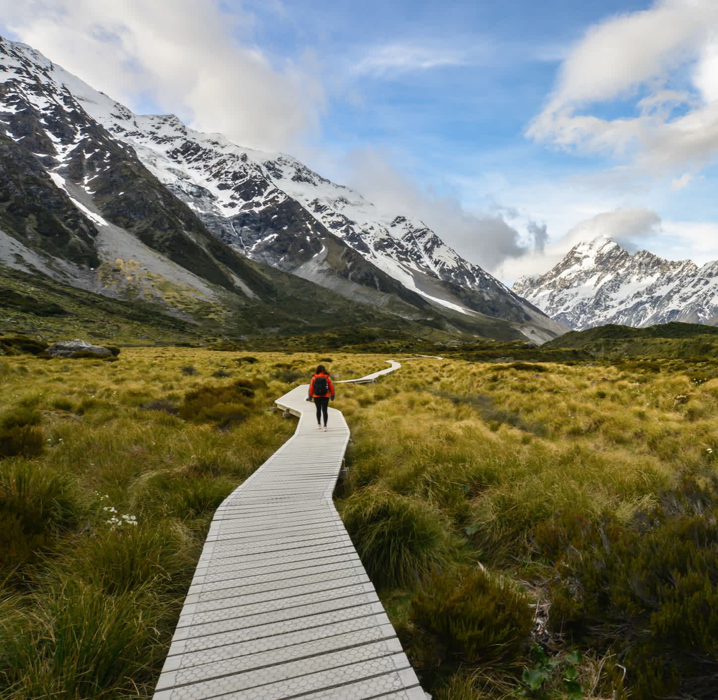 Femme avec un sac à dos à pied sur le chemin en bois du Mont Cook en Nouvelle-Zélande