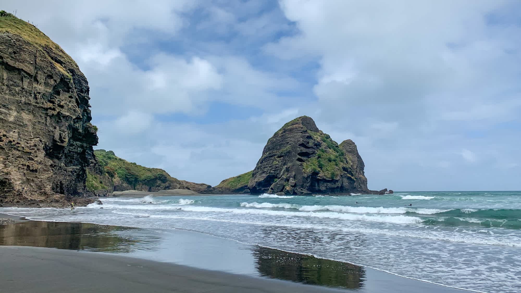 Sable noir, falaises dans l'eau de la plage de Piha à Auckland, Nouvelle-Zélande