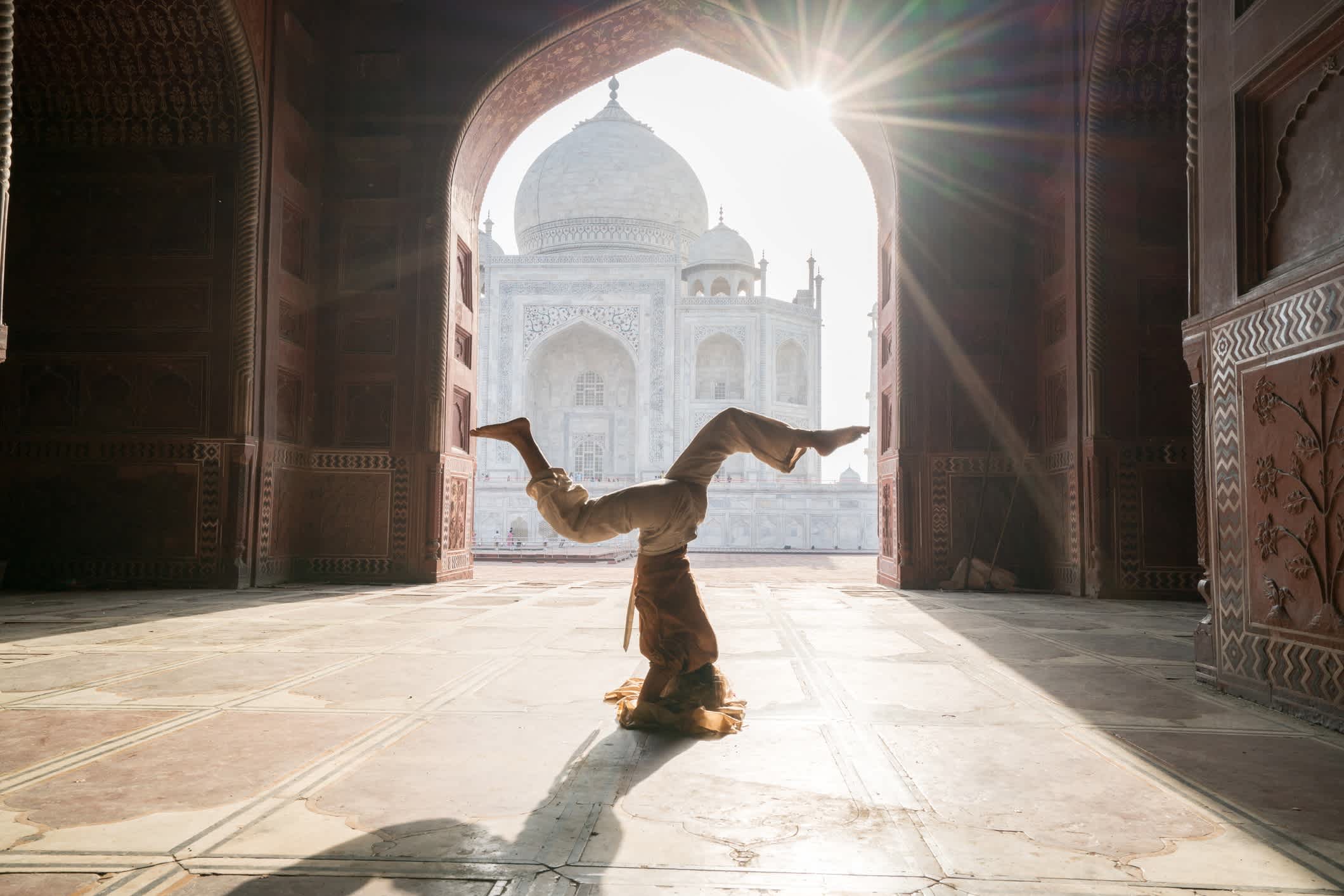 Frau macht Yoga mit Taj Mahal im Hintergrund