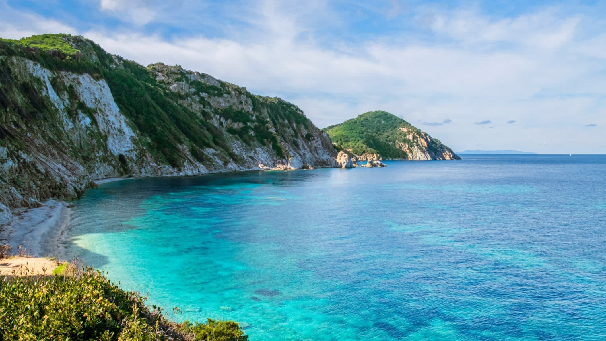 Blick auf den Sansone Beach auf Elba, Toskanischen Archipel, Italien sowie das blaue Meer, das Riff und die umliegenden Klippen.