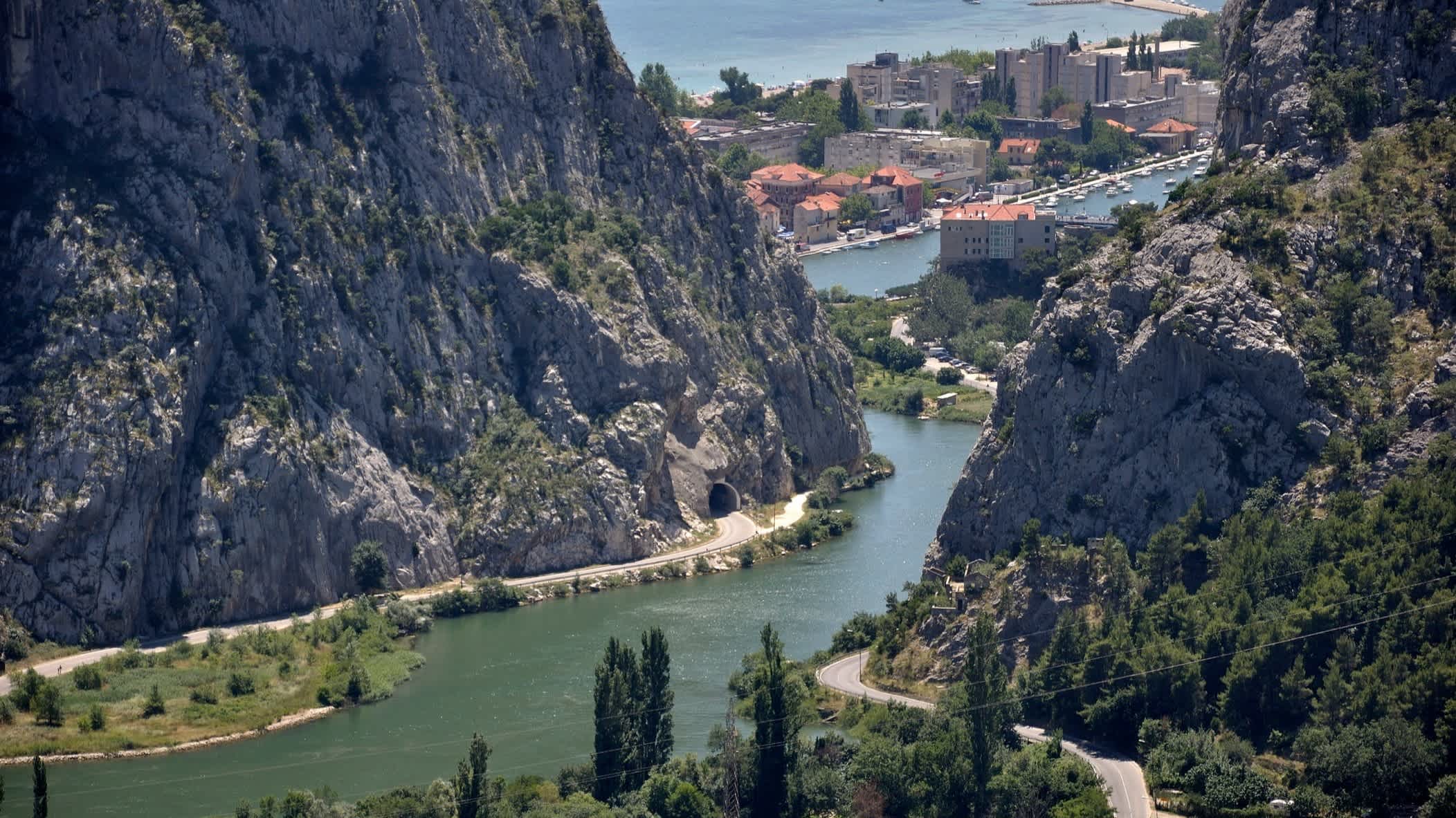 Die Küstenstadt Omiš und der Fluss Cetina in Kroatien mit Blick aus der Luft auf die Felsen, Die Stadt und das Meer.
