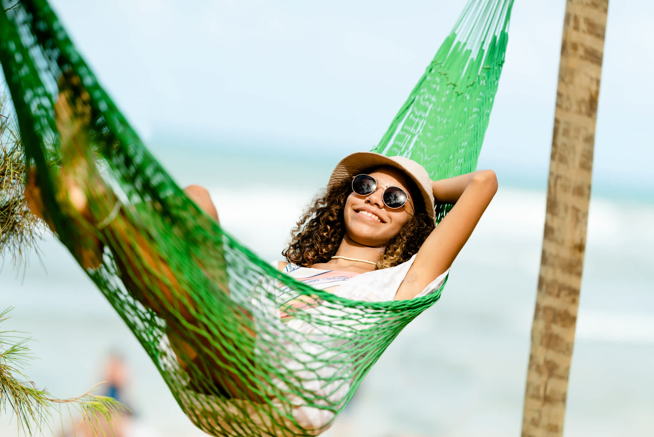 Junge Frau entspannen in einer Hängematte am Strand in Brasilien.
