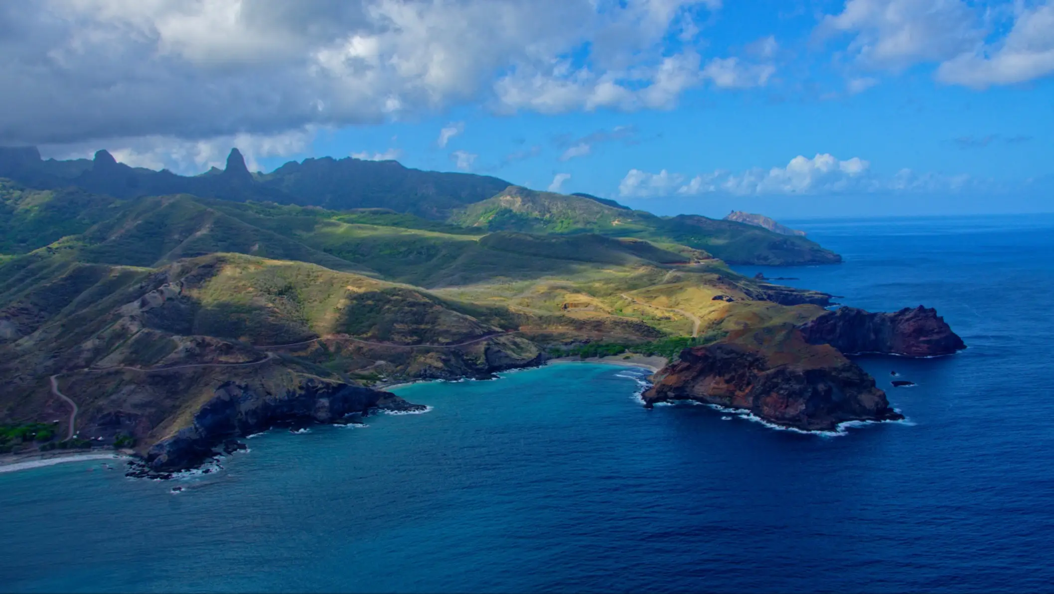 Vue aérienne de l'île de Ua Pou, avec montagnes verdoyantes, côtes rocheuses et eaux turquoise, Polynésie Française.